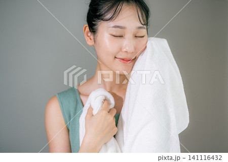 洗顔してタオルで顔を拭く女性 141116432