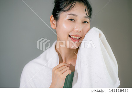 洗顔してタオルで顔を拭く女性 洗顔してタオルで顔を拭く女性 141116433
