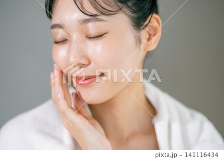 洗顔してタオルで顔を拭く女性 洗顔してタオルで顔を拭く女性 141116434