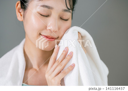 洗顔してタオルで顔を拭く女性 洗顔してタオルで顔を拭く女性 141116437