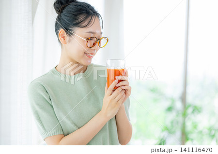 トマトジュースを飲む若い女性 トマトジュースを飲む若い女性 141116470