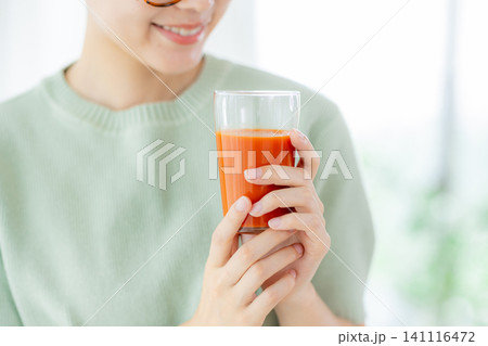 トマトジュースを飲む若い女性 141116472