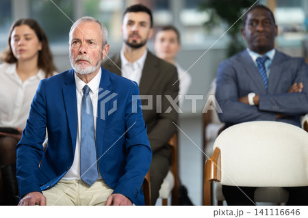 elderly man listens to a speaker at a conference on finance 141116646