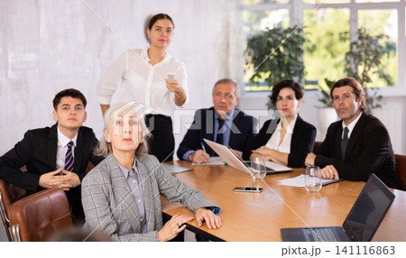 Woman and man sitting at table beside during meeting in conference room 141116863