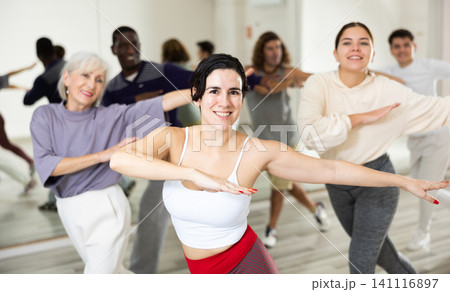 Young Hispanic woman learning dynamic dances in choreography class Young Hispanic woman learning dynamic dances in choreography class 141116897