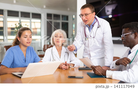 Male doctor speaks at meeting of colleagues and tells reports on condition of patients. Male doctor speaks at meeting of colleagues and tells reports on condition of patients. 141117049