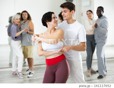 Hispanic woman and guy learning pair dances in choreography class Hispanic woman and guy learning pair dances in choreography class 141117052