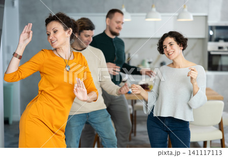 Men and women doing couple dancing during house party. Men and women doing couple dancing during house party. 141117113