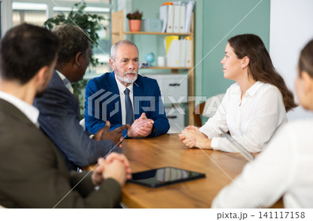Group of businessmen and businesswomen holding meeting at table Group of businessmen and businesswomen holding meeting at table 141117158