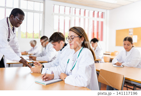 Girl medical student listening to lecture in classroom Girl medical student listening to lecture in classroom 141117196