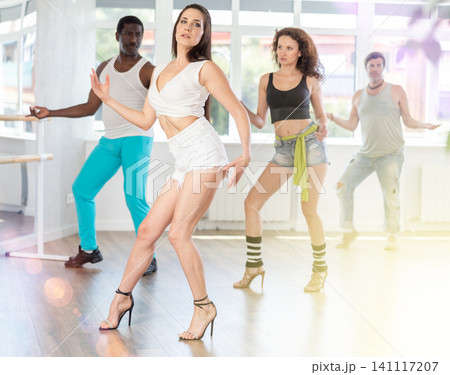 Female dancer practicing jazz-funk dance in studio with group 141117207