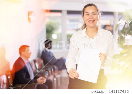 Happy young woman standing with her back to waiting room Happy young woman standing with her back to waiting room 141117436