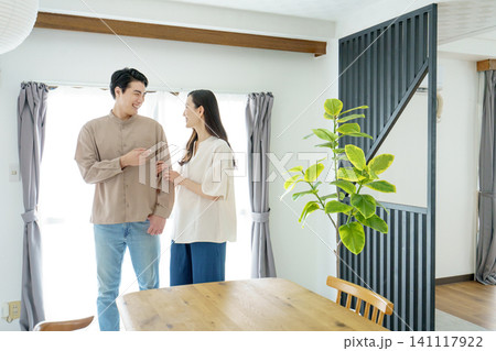 リビングで、男性の腕に手を回す若い日本人女性 リビングで、男性の腕に手を回す若い日本人女性 141117922