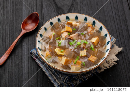traditional Chinese sweet potato starch jelly soup with tofu cubes and green onions in a ceramic bowl traditional Chinese sweet potato starch jelly soup with tofu cubes and green onions in a ceramic bowl 141118075