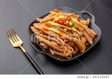 shaanxi style buckwheat Liangpi cold noodles with cucumber shreds and chili slices on a plate shaanxi style buckwheat Liangpi cold noodles with cucumber shreds and chili slices on a plate 141118207