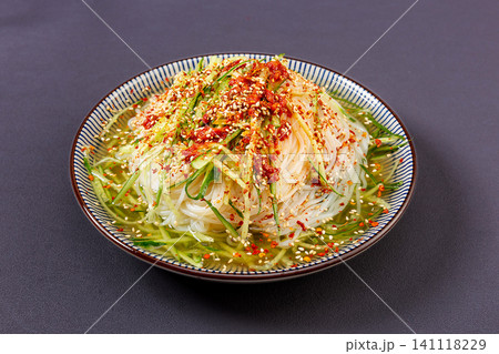 traditional Korean-Chinese style cold noodles topped with chili powder, cucumber, and sesame seeds 141118229