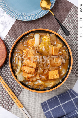 braised flat sweet potato glass noodles with fried tofu and cabbage in a ceramic bowl braised flat sweet potato glass noodles with fried tofu and cabbage in a ceramic bowl 141118270