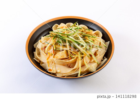 spicy cold dried mianpi wheat noodles with shredded cucumber served on a wooden tray spicy cold dried mianpi wheat noodles with shredded cucumber served on a wooden tray 141118298