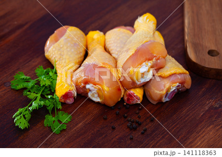 Raw chicken legs on wooden table 141118363