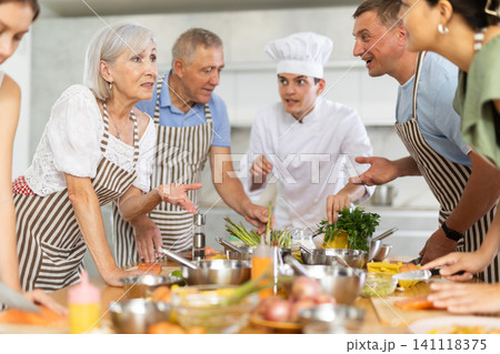 Healthy food master class. Chef apprentices learn how to cook delicious salmon fillet 141118375