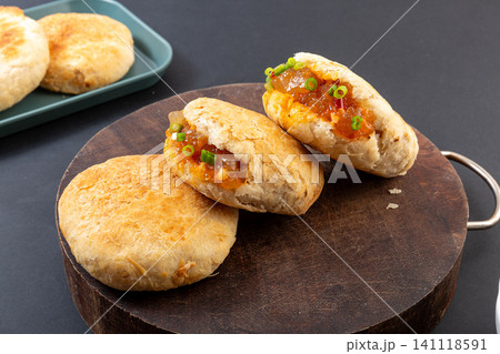 Chinese crispy shaobing flatbread stuffed with savory spicy starch jelly on wooden board Chinese crispy shaobing flatbread stuffed with savory spicy starch jelly on wooden board 141118591