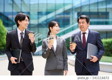 休憩中に談笑をしながら歩くビジネスパーソン 休憩中に談笑をしながら歩くビジネスパーソン 141118872