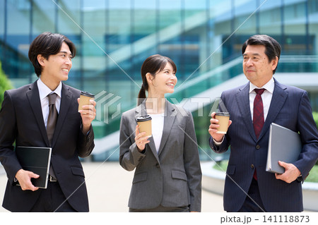 休憩中に談笑をしながら歩くビジネスパーソン 休憩中に談笑をしながら歩くビジネスパーソン 141118873