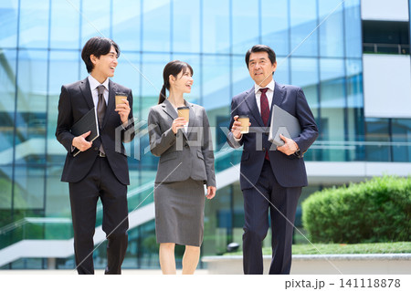 休憩中に談笑をしながら歩くビジネスパーソン 休憩中に談笑をしながら歩くビジネスパーソン 141118878