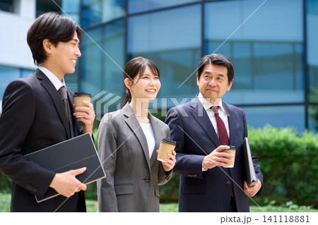 休憩中に談笑をしながら歩くビジネスパーソン 休憩中に談笑をしながら歩くビジネスパーソン 141118881