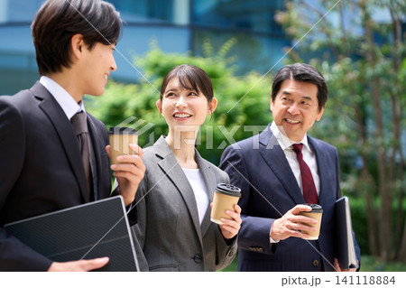 休憩中に談笑をしながら歩くビジネスパーソン 休憩中に談笑をしながら歩くビジネスパーソン 141118884