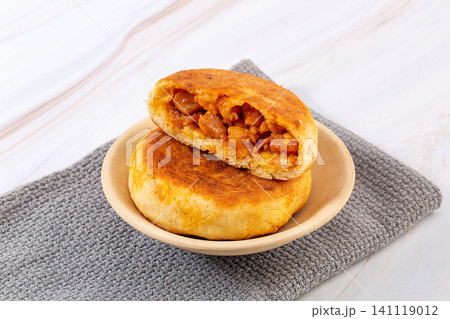 chinese pan fried meat pies stuffed with New Orleans chicken chunks in white ceramic bowl chinese pan fried meat pies stuffed with New Orleans chicken chunks in white ceramic bowl 141119012