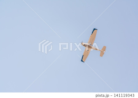 Small ultralight airplane with overhead wing and single propeller flying in sunset sky. Small ultralight airplane with overhead wing and single propeller flying in sunset sky. 141119343