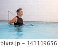 プールで水中ウォーキングをする笑顔のシニア男性 141119656