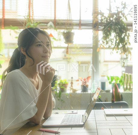 ノートパソコンに向かう若い日本人女性 ノートパソコンに向かう若い日本人女性 141119895