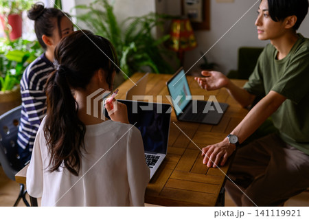 ノートPCを囲んで議論する3人 141119921