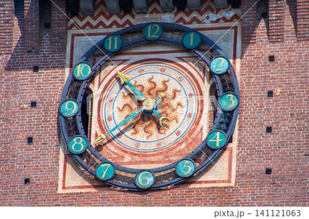 Antique Astronomical Clock on the Brick Castle Tower with a Golden Sun Dial and Numbers. Milan Castle wall tower facade. Italian architecture 141121063