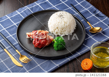 stir-fried pork cartilage moon bone served with steamed white rice and broccoli on plate. stir-fried pork cartilage moon bone served with steamed white rice and broccoli on plate. 141121168