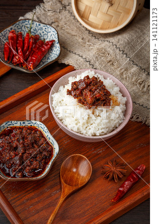 A bowl of steamed rice topped with savory beef chili sauce, traditional Chinese condiment. A bowl of steamed rice topped with savory beef chili sauce, traditional Chinese condiment. 141121173