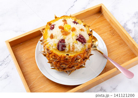 sweet pineapple sticky rice with jujube and raisins served in a whole pineapple shell. sweet pineapple sticky rice with jujube and raisins served in a whole pineapple shell. 141121200