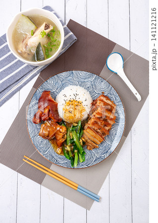 braised pork feet and sliced pork belly combo rice with green vegetables on a decorative plate. braised pork feet and sliced pork belly combo rice with green vegetables on a decorative plate. 141121216
