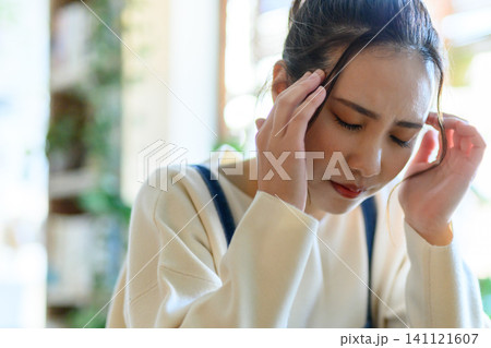 両手で頭を抱え悩む女性 両手で頭を抱え悩む女性 141121607