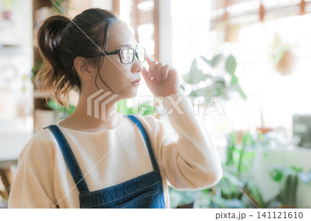 眼鏡を調整する30代の日本人女性 眼鏡を調整する30代の日本人女性 141121610