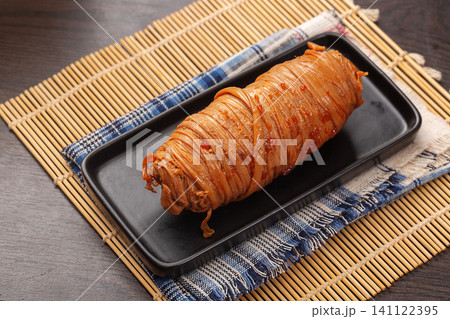 chinese braised pork small intestine wrapped with string on black plate chinese braised pork small intestine wrapped with string on black plate 141122395