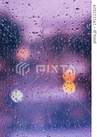 Raindrops on window with blurred purple and white lights Raindrops on window with blurred purple and white lights 141122824