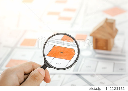 Man holding magnifier on cadastre map search for assesses to buy the land lands. real estate concept with vacant land for building construction and housing subdivision for sale, rent, buy, investment. Man holding magnifier on cadastre map search for assesses to buy the land lands. real estate concept with vacant land for building construction and housing subdivision for sale, rent, buy, investment. 141123181