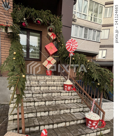 Christmas porch decoration with pine garland and hanging gift boxes, festive entrance design for New Year holidays. Christmas porch decoration with pine garland and hanging gift boxes, festive entrance design for New Year holidays. 141124665