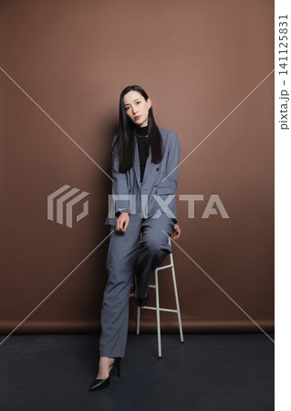 椅子に座るスーツの女性 椅子に座るスーツの女性 141125831