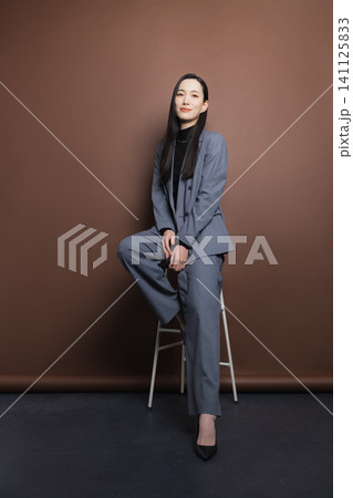 椅子に座るスーツの女性 椅子に座るスーツの女性 141125833