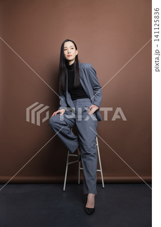 椅子に座るスーツの女性 椅子に座るスーツの女性 141125836