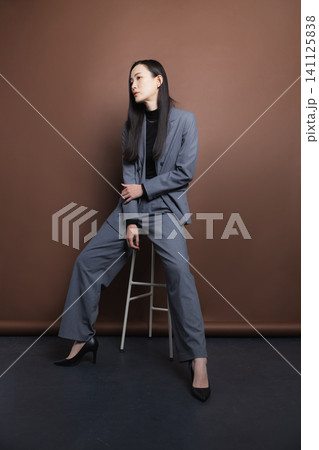 椅子に座るスーツの女性 椅子に座るスーツの女性 141125838